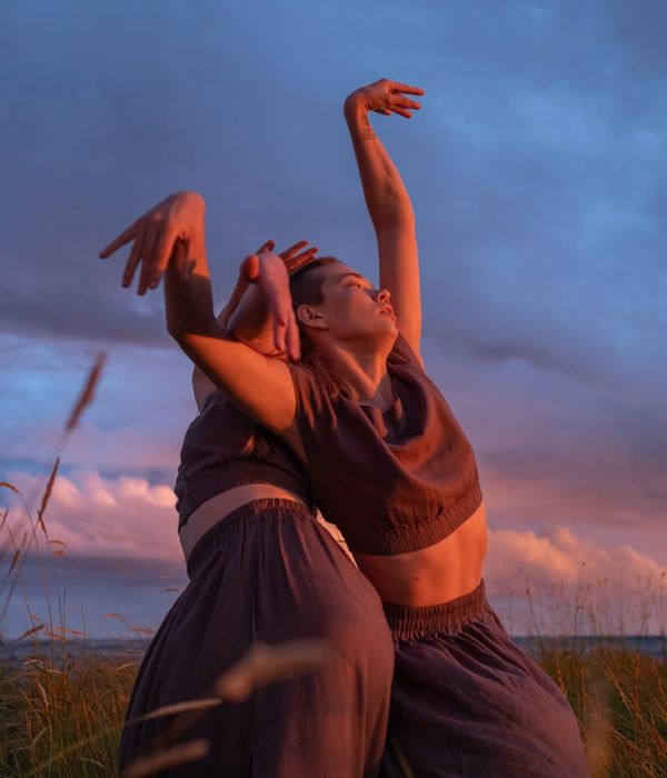 Woman performing a fluid movement in a calm natural setting.